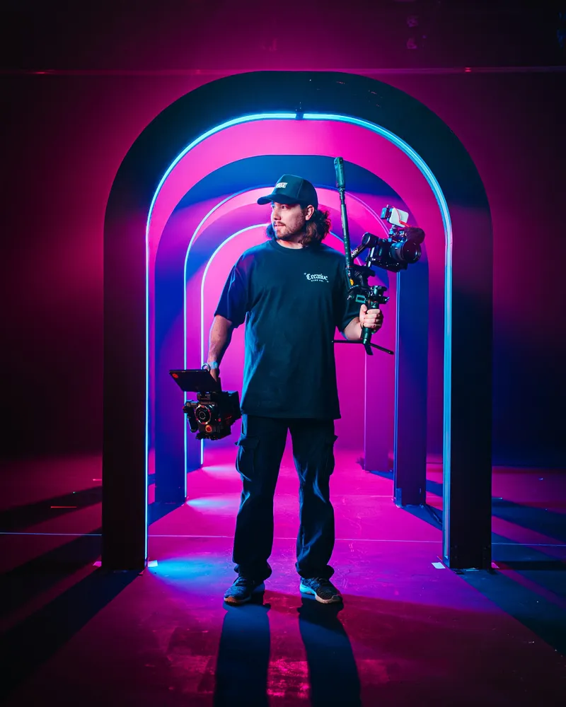 Alex with a camera rig in a neon tunnel